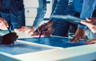 group of people drawing blueprints